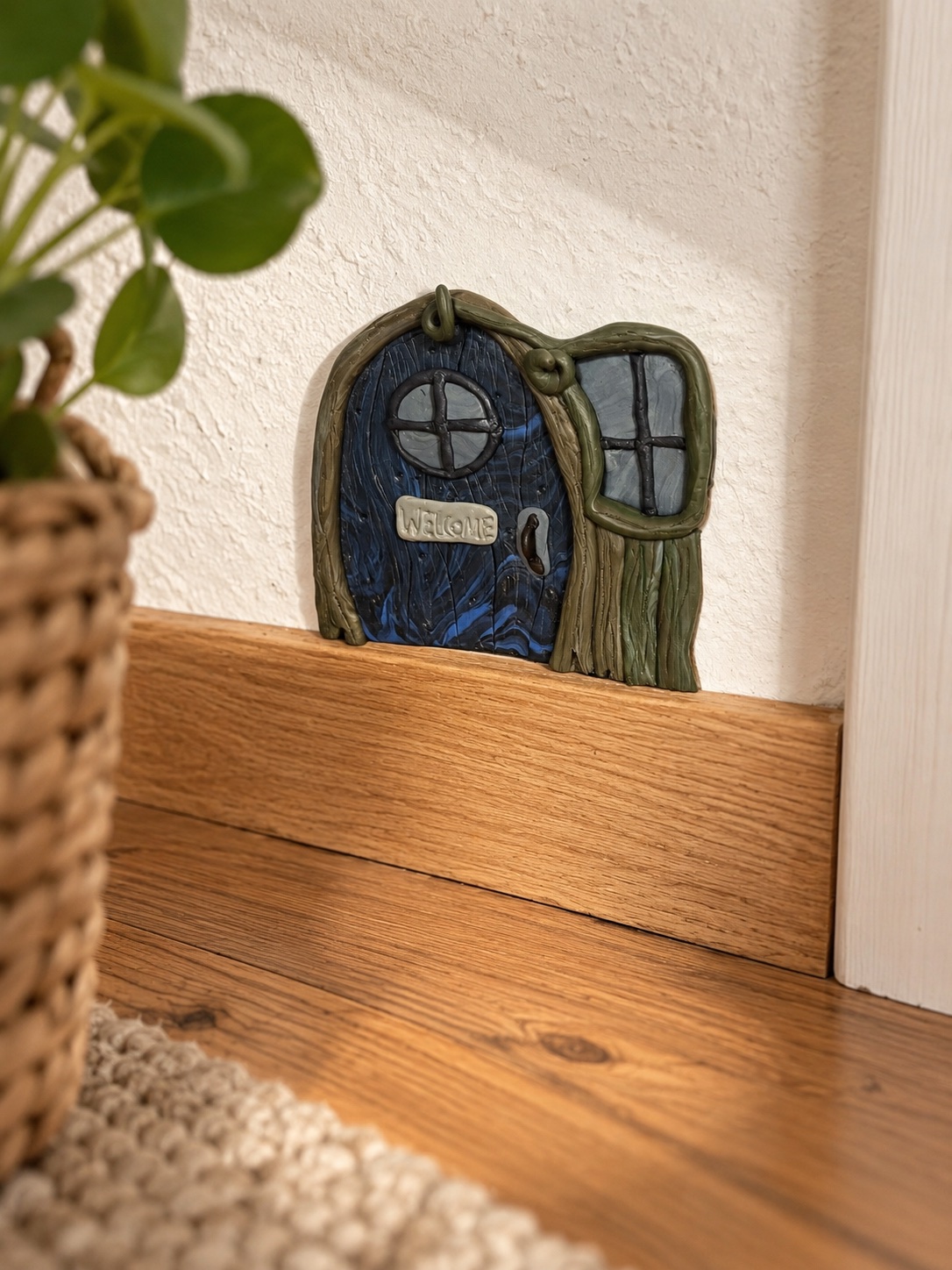 Waldwichteltür aus FIMO in Grün und Blau selber machen Handmodellierte Wichteltür aus Polymer Clay in der Hand